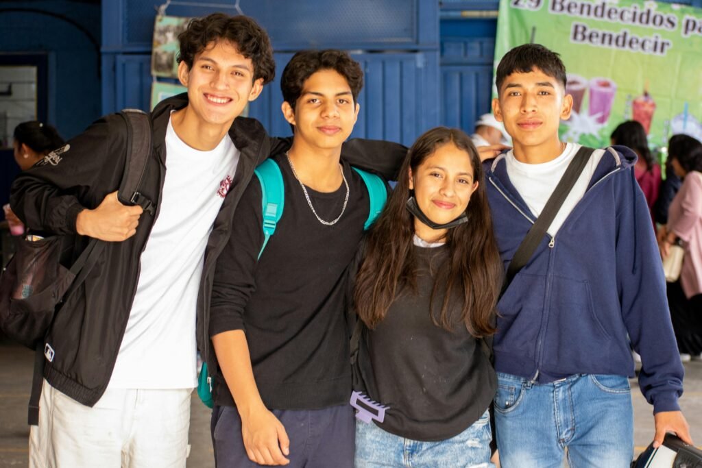 A cheerful group of teenagers smiling together at school, symbolizing friendship and happiness.